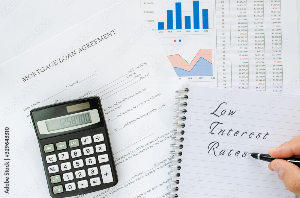 Low Interest Rate written in handwriting on note pad in a conceptual image of paying lesser rates and saving money. Low Interest Rate written in handwriting on note pad in a conceptual image of paying lesser rates and saving money.