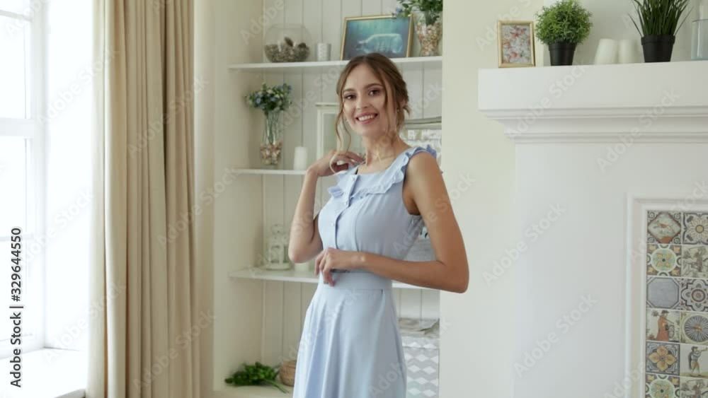 A young girl dancing in a dress and jacket next to a chair and a window in a beautiful interior, in a house A young girl dancing in a dress and jacket next to a chair and a window in a beautiful interior, in a house