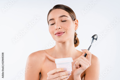 Young beautiful caucasian woman enjoying yogurt isolated on white background