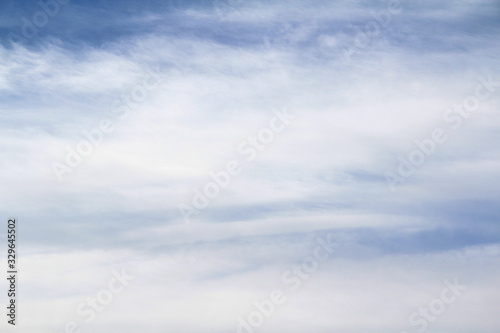 Cloudy blue sky with white and gray clouds. Background for text and design.
