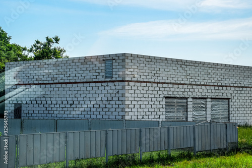 building is made of white foam block and a gray metal fence.