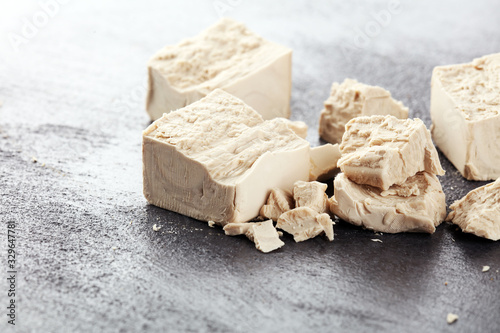 Dry yeast crumbled and yeast block for baking on background