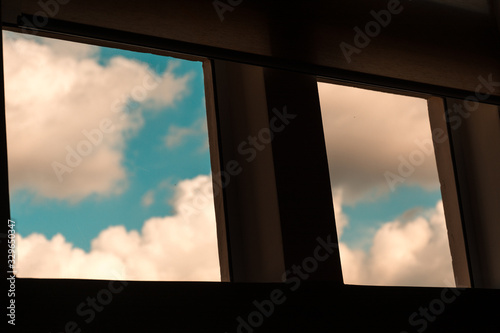 Square windows that shows a clear blue sky at the outside.