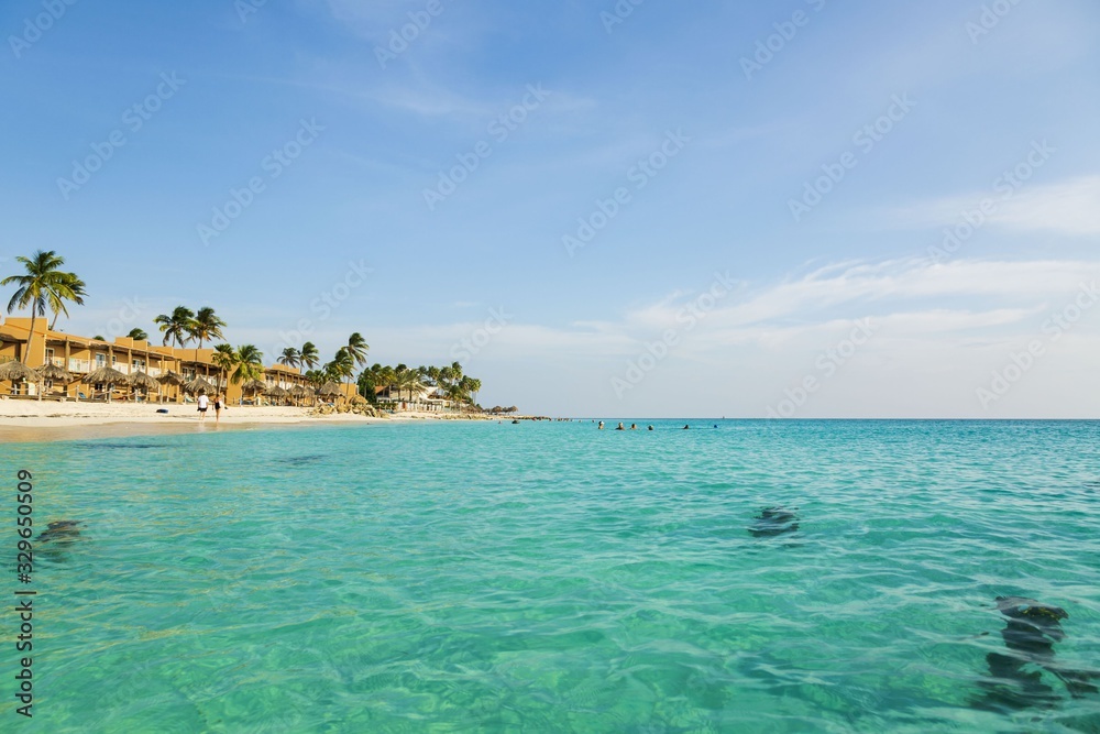 Amazing view of turquoise water of Atlantic ocean and blue sky with white clouds. Eagle Beach of Aruba Island. Caribbean. Beautiful nature background. Amazing view of turquoise water of Atlantic ocean and blue sky with white clouds. Eagle Beach of Aruba Island. Caribbean. Beautiful nature background.