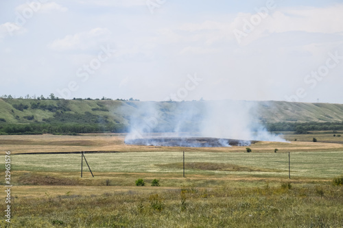 Fire in field where hay was grown. burning dry grass