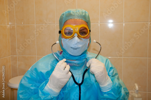 A doctor in a suit of bacteriological protection is preparing to receive a patient for coronavirus