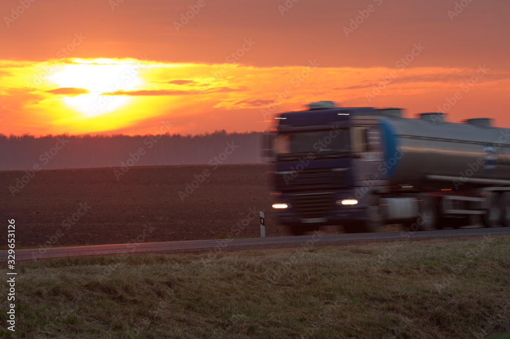  fuel truck rides on the road at sunset