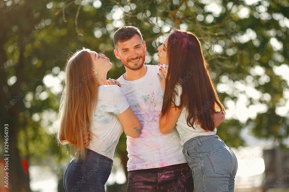 Fototapeta premium Friends with a holi paints. People in a summer park. Students have fun.