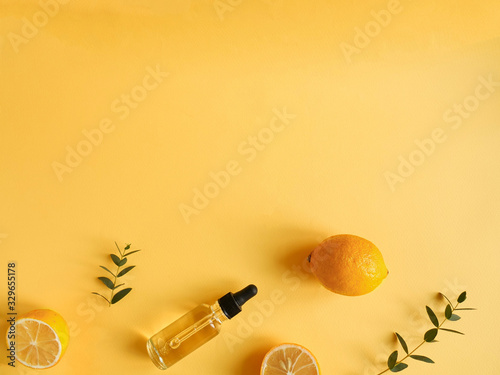 bright flatlay composition with oil, citrus and eucalyptus. on yellow background. Concept beauty natural vitamin cosmetic product, skin care, copyspace, top view
