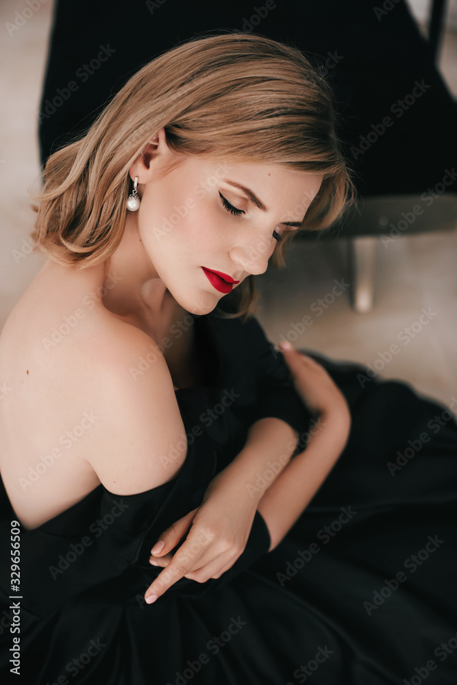 Beautiful fashion model in black dress ,Woman with hair, Red lipstick . Portrait of glamour blonde girl with bright makeup. Beautiful fashion model in black dress ,Woman with hair, Red lipstick . Portrait of glamour blonde girl with bright makeup.