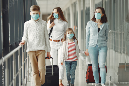 People in airport are wearing masks to protect themselves from virus.