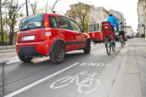 Dangerous encounter between cyclists, cars and tram at the end of a marked bike path on busy road with lots of traffic in Vienna, Austria.