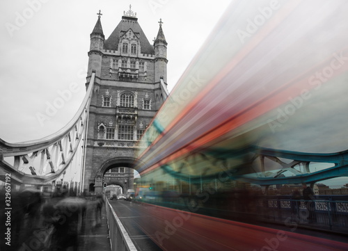 Fototapeta Naklejka Na Ścianę i Meble -  Tower Bridge in London, UK in Twilight - Black and white motion blur of double decker bus on Tower Bridge London, UK. Red double-decker bus leaving light traces. London traffic blur on the bridge