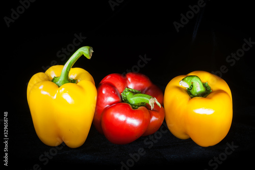 Red Pepper between two Yellow Ones on Black