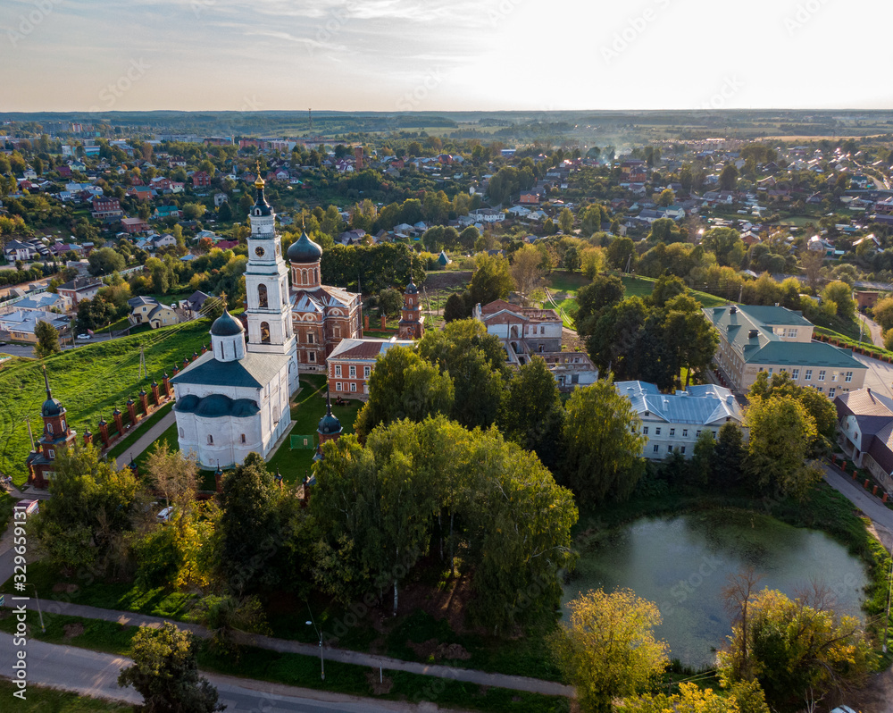 Aerial photo of the old Russian Kremlin in Volokolamsk, near the lake, in the background nature and country houses.