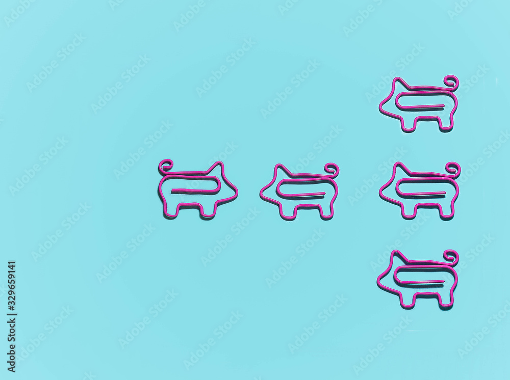 top view of group with piggy paper clips in one direction and one leader opposite on blue background, leadership concept top view of group with piggy paper clips in one direction and one leader opposite on blue background, leadership concept
