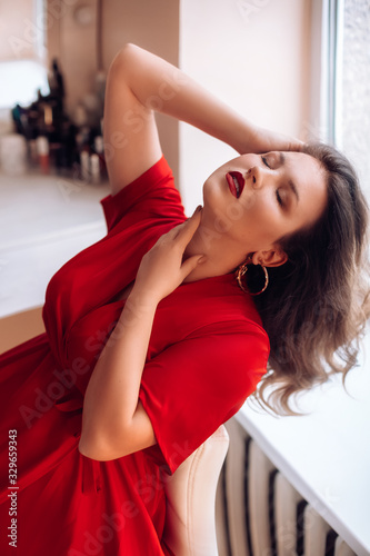 Portrait of beautiful young woman with makeup in fashion red clothes