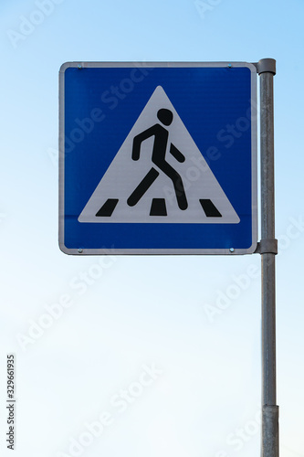 zebra crossing road sign against a blue sky. Traffic sign pedestrian crossing.