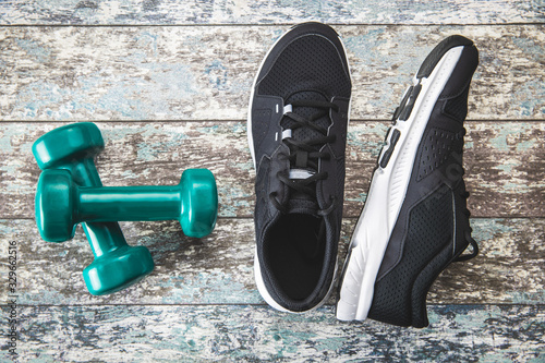 Black sport shoes and green dumbbells.