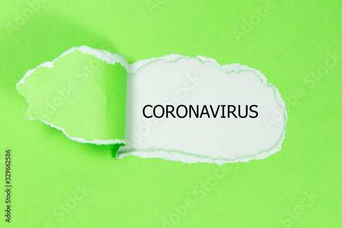 The word CORONAVIRUS appearing behind torn paper