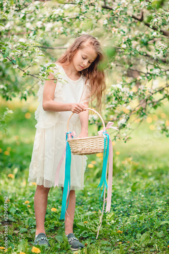 Adorable little girl in blooming apple garden on beautiful spring day