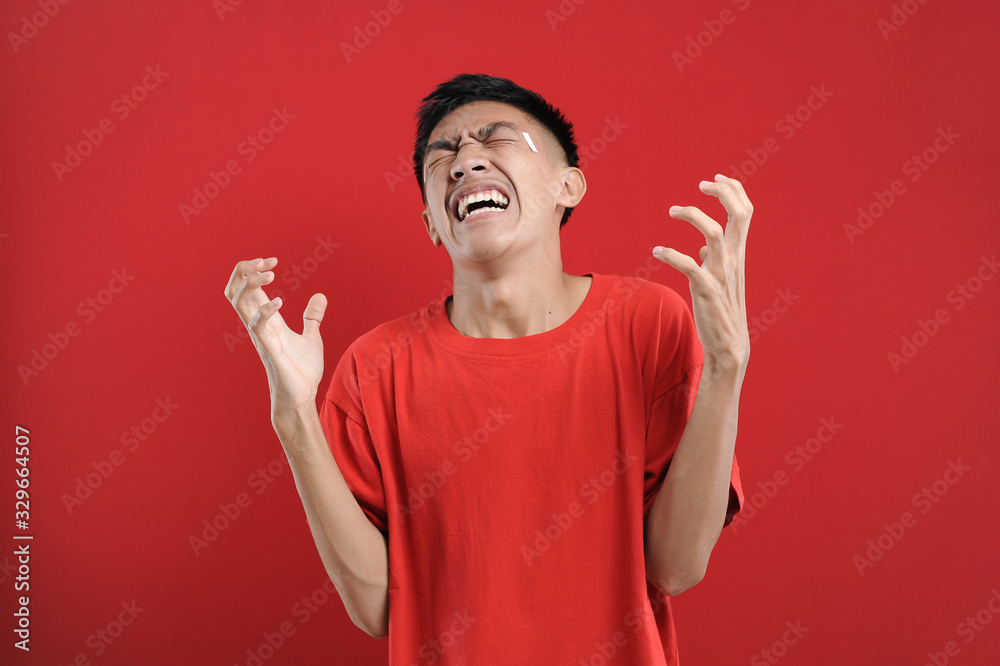 Fototapeta premium Young Asian man doing angry gesture, annoyed, and emotional