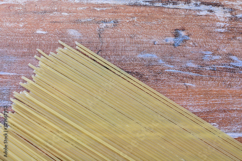 Italian long pasta, on textured wooden background