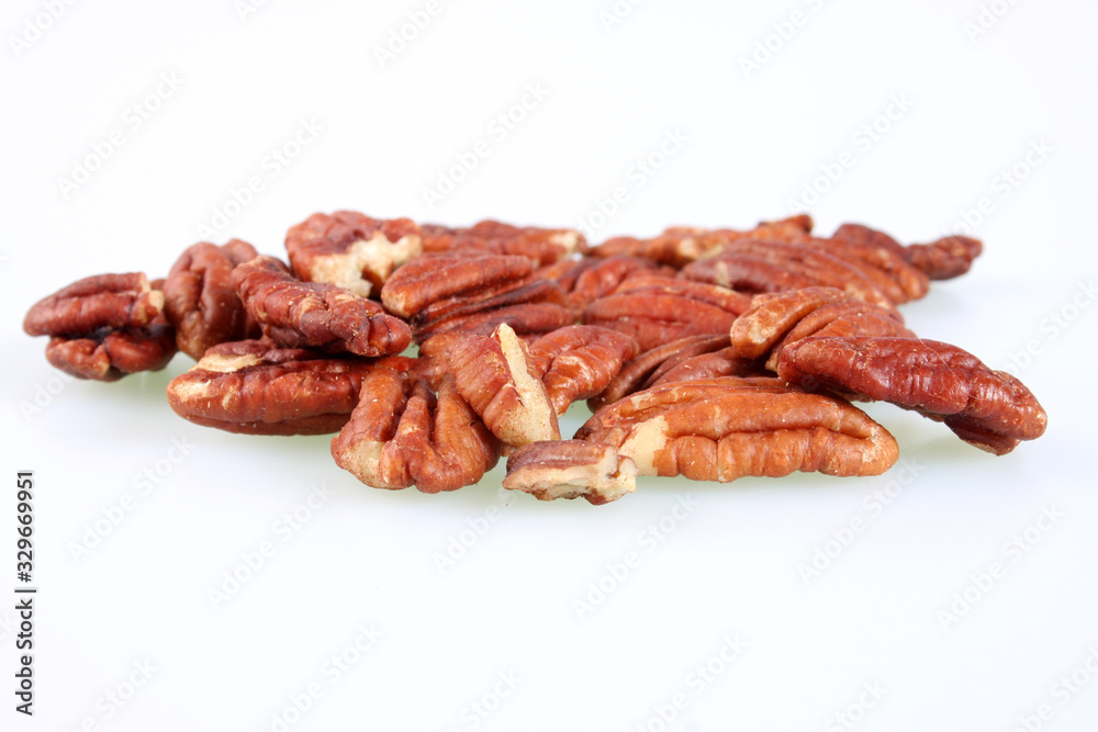 A studio photograph of a handful of pecan nuts