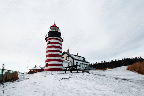 Snow Covered Red Striped Lighthouse on the Coast of Maine
