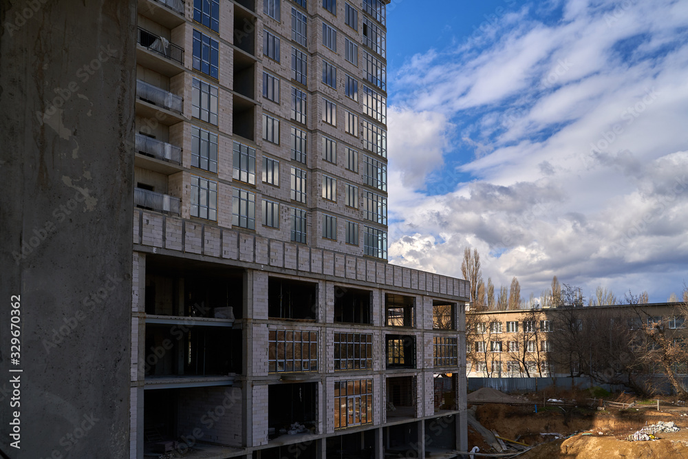 Fototapeta premium Construction site. High rise Building under construction. Construction of high-rise residential building