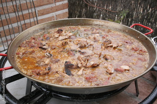 Paella being cooked outside in a huge paella pan