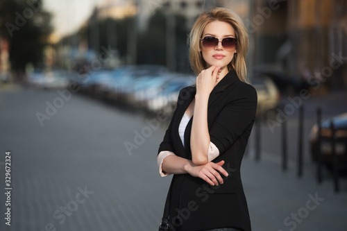 Young fashion blond business woman in black blazer and sunglasses