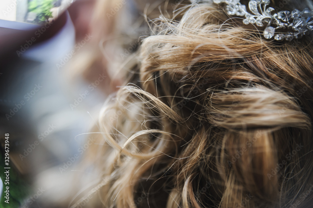 Naklejka premium Bridal wedding hairstyle. Tender wedding stylish hairstyle. Elegant bride standing back with collected up do hair. Fine art wedding. Light bridal morning preparation.