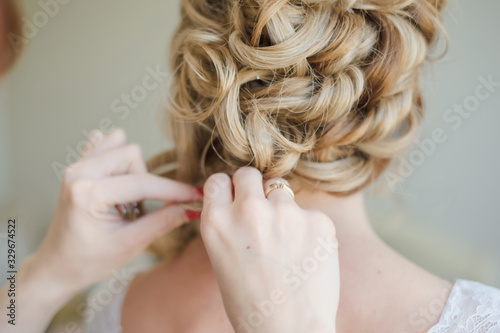 Bridal wedding hairstyle. Tender wedding stylish hairstyle. Elegant bride standing back with collected up do hair. Fine art wedding. Light bridal morning preparation.