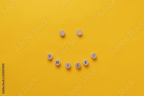 Smile sign and smiling face made of wooden cut circles