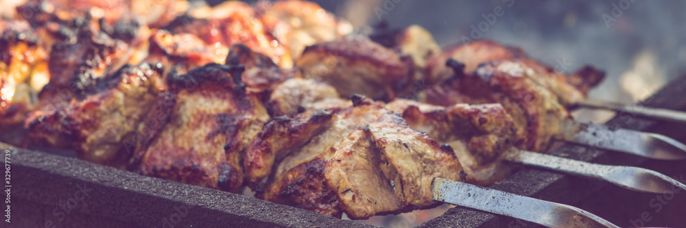 Grilled kebab cooking on metal skewer, roasted pork meat cooked at bbq closeup. Grilled kebab cooking on metal skewer, roasted pork meat cooked at bbq closeup.
