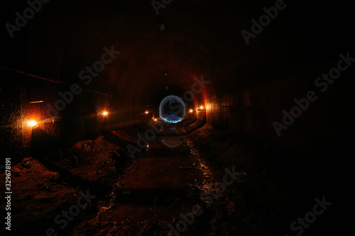 Dark dirty flooded abandoned vaulted drainage tunnel
