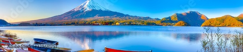 Asian Japan Travel Destinations. Panoramic Image of Renowned Marvelous Fuji Mountain At Kawaguchiko Lake in Japan With Line of Colorful Boats in Foregound.
