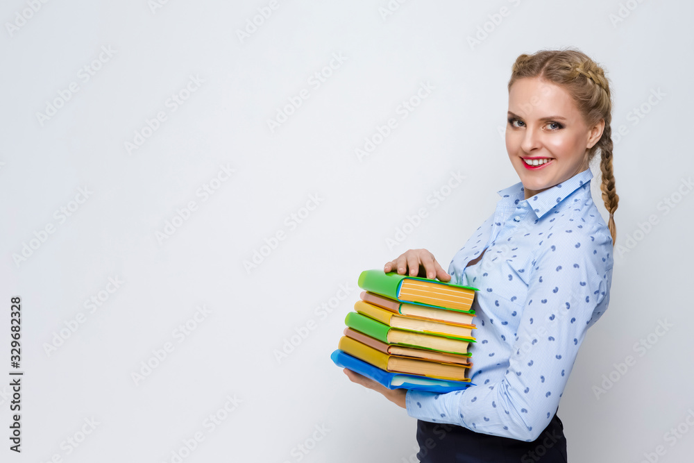 Education Concepts and Ideas. Caucasian Blond Female Posing With Heap of Books in Colorful Covers With Pleased Facial Expression. Against White. Education Concepts and Ideas. Caucasian Blond Female Posing With Heap of Books in Colorful Covers With Pleased Facial Expression. Against White.