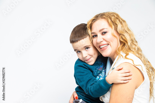 Portrait of Happy Loving Caucasian Mother With Her Son in Studio Indoors. Posing Against White Background.