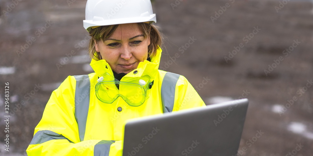 woman civil engineer close up. young woman using laptop on construction site. woman engineer developer holding laptop working Confident outdoors in construction site. Woman architect inspecting site. - obrazy, fototapety, plakaty 