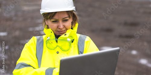 woman civil engineer close up. young woman using laptop on construction site. woman engineer developer holding laptop working Confident outdoors in construction site. Woman architect inspecting site. photo