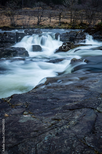 the waterfalls in Glen Orchy near Bridge of Orchy in the Argyll region of the highlands of Scotland during winter whilst the river is flowing fast from rainfall