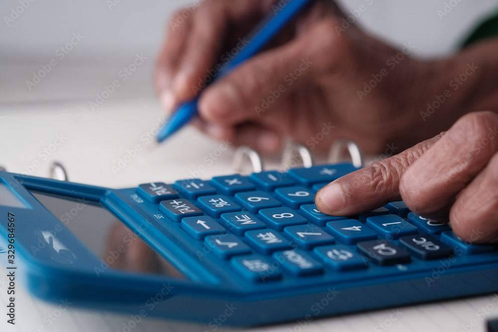 senior women use calculator and writing on notepad senior women use calculator and writing on notepad