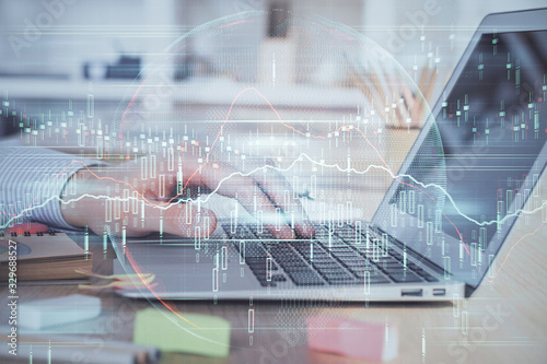 Double exposure of stock market graph with man working on laptop on background. Concept of financial analysis.