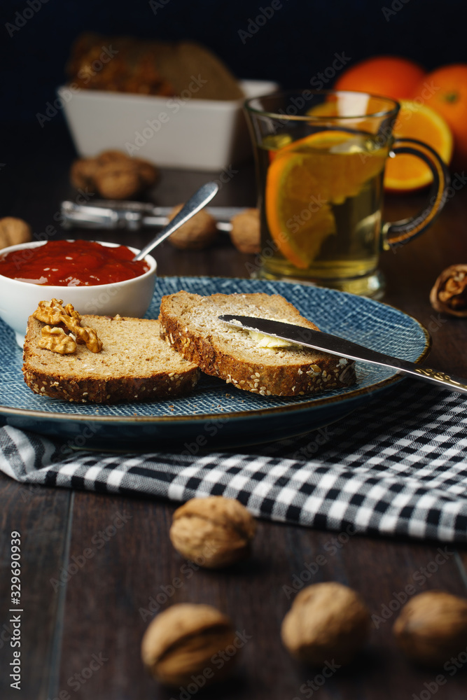 Breakfast, bread and butter with jam and tea on a dark wooden background Breakfast, bread and butter with jam and tea on a dark wooden background