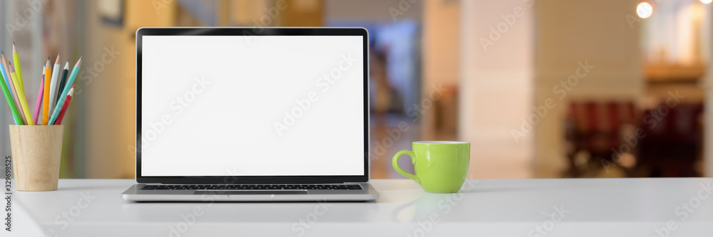 Cropped shot of simple workspace with blank screen laptop, cup, stationery and copy space Cropped shot of simple workspace with blank screen laptop, cup, stationery and copy space