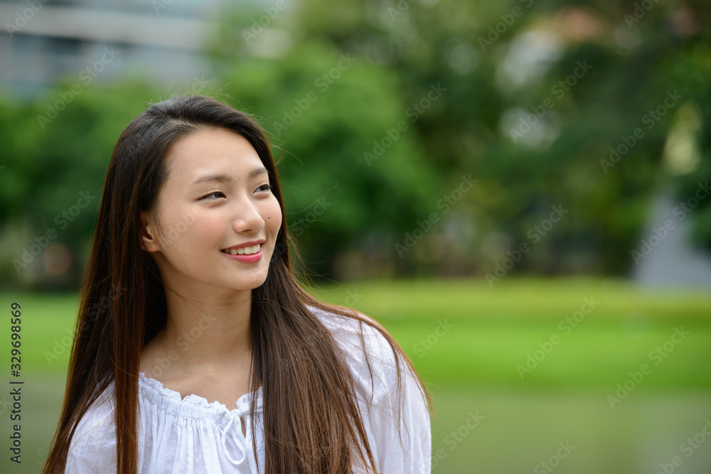 Happy young beautiful Asian teenage girl thinking at the park Happy young beautiful Asian teenage girl thinking at the park