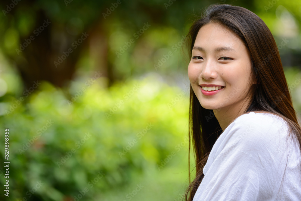 Happy young beautiful Asian teenage girl at the park Happy young beautiful Asian teenage girl at the park