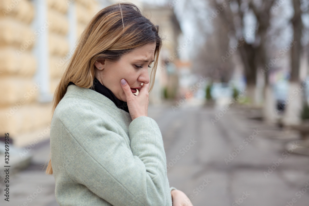 Depressed sad woman in profile almost crying on a city street Depressed sad woman in profile almost crying on a city street